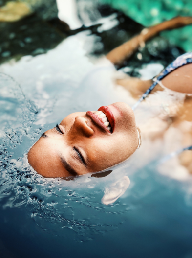 A woman is floating in a pool with her head in the water and smiling. A woman is floating in a pool with her head in the water and smiling.