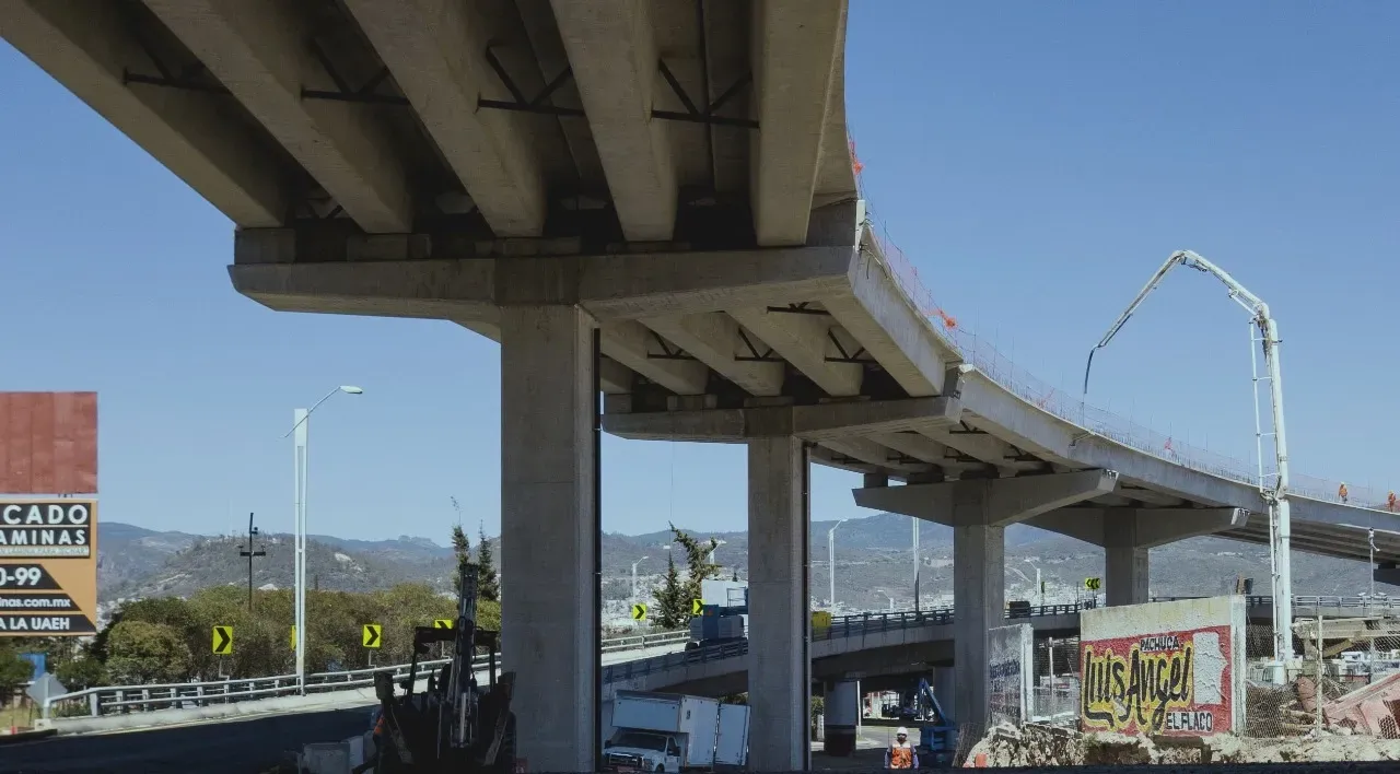 Concrete highway overpass under construction with a blue sky background.