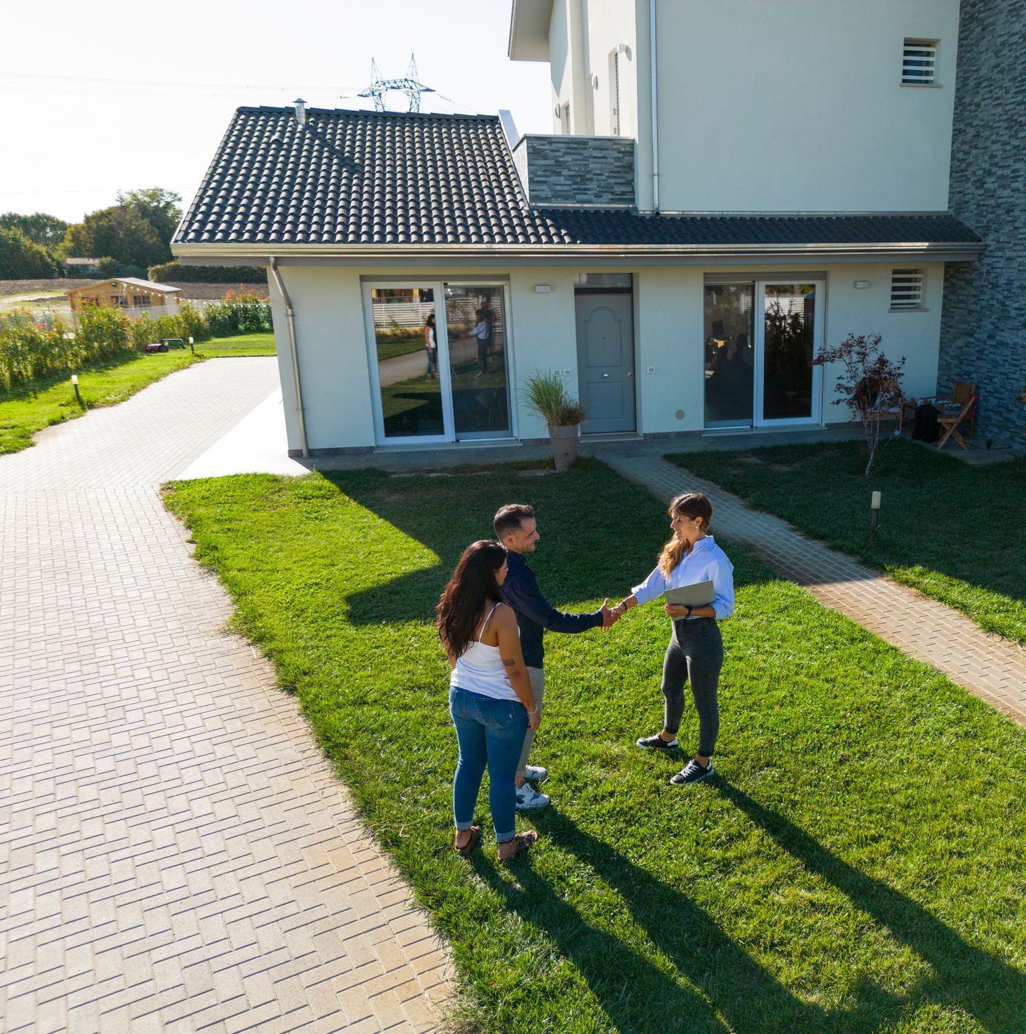 An aerial view of a couple standing in front of a house