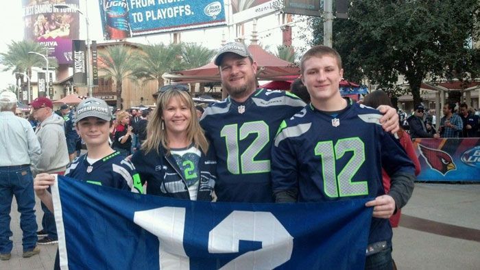 Family of four in Seahawks jerseys holding a