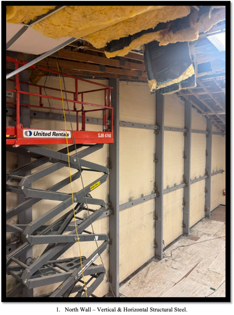 Scissor lift beside framed wall studs and exposed insulation inside the family life center under construction
