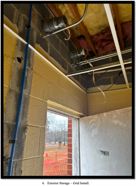 Interior of the family life center under construction, with exposed ceiling pipes and an open doorway.