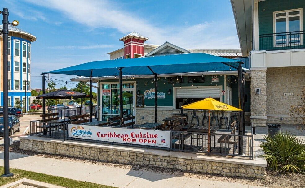 the outside of a restaurant with tables and umbrellas