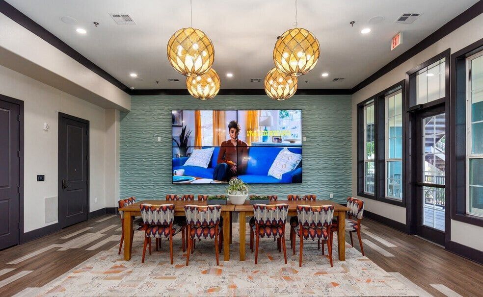 a dining room with a table and chairs and a tv on the wall