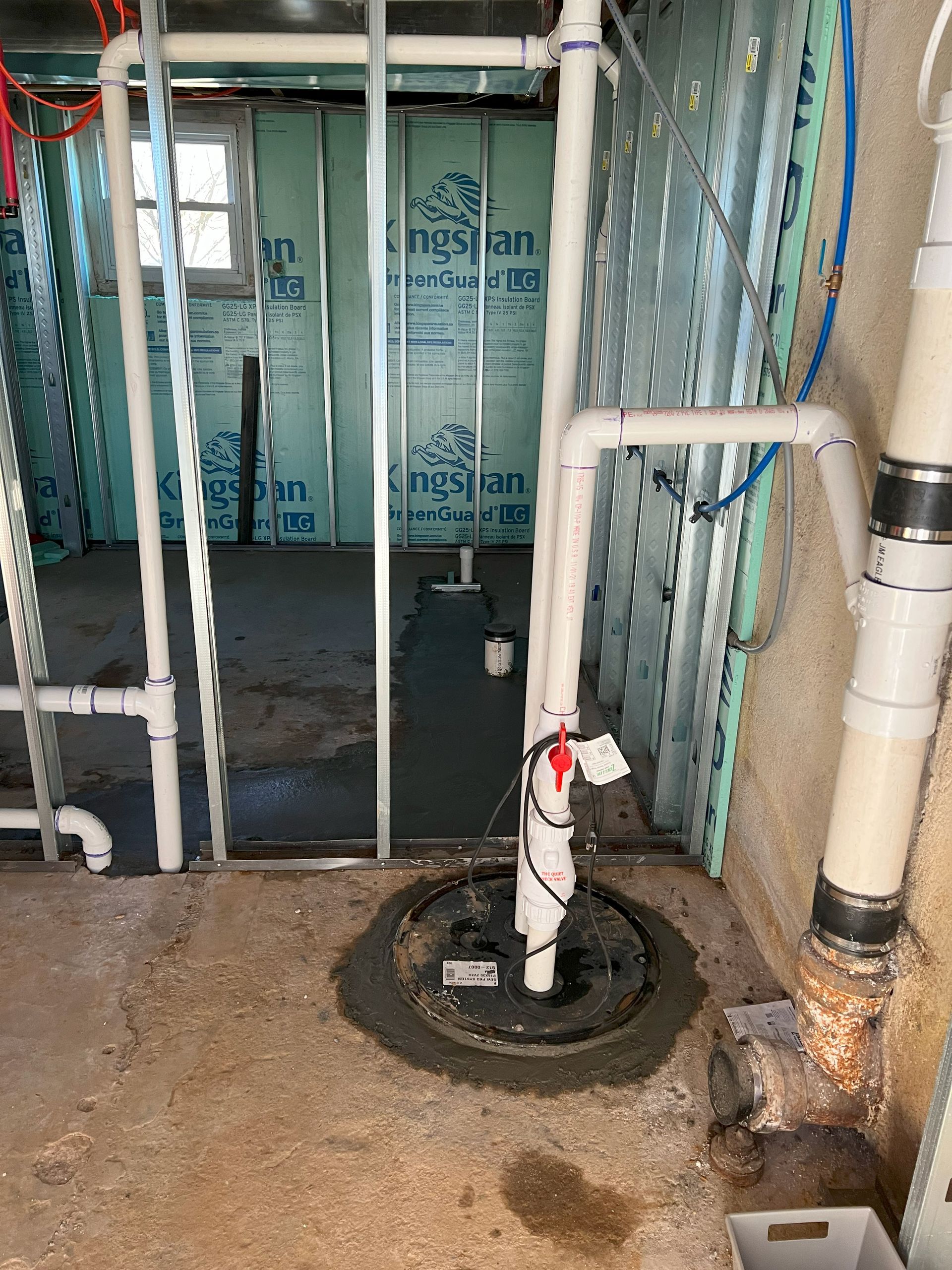 Recently completed basement bathroom rough-in with ejector pump installation and sewer pipe replacement. 