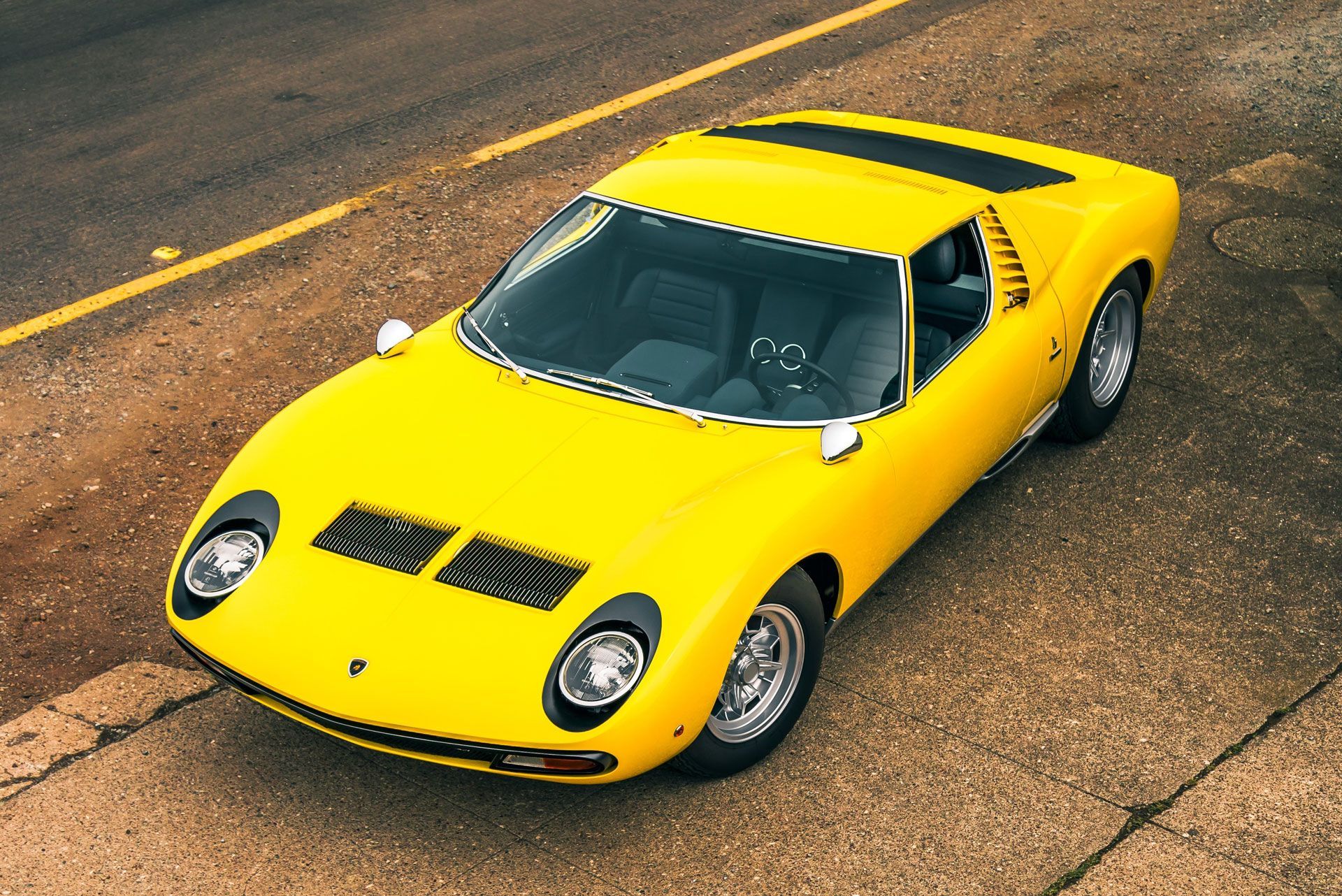 A yellow sports car is parked on the side of the road.