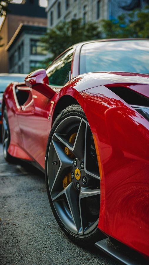 A red sports car is parked on the side of the road.