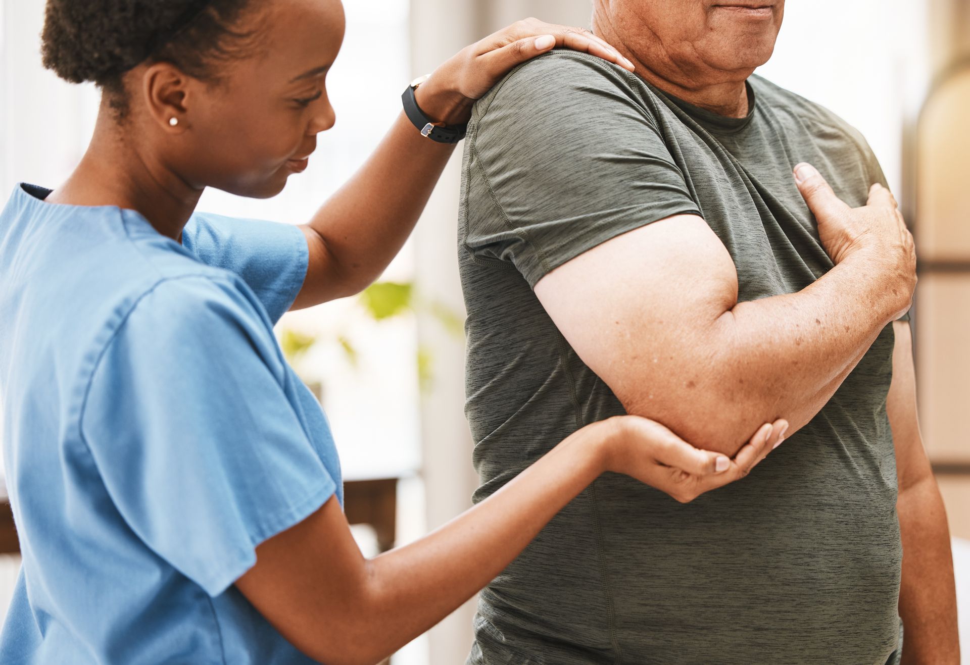 Healthcare worker checking a patient’s arm in a clinical setting