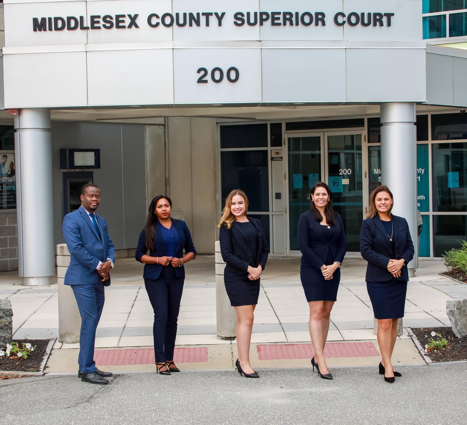 Group of five people in suits outside Middlesex County Superior Court.