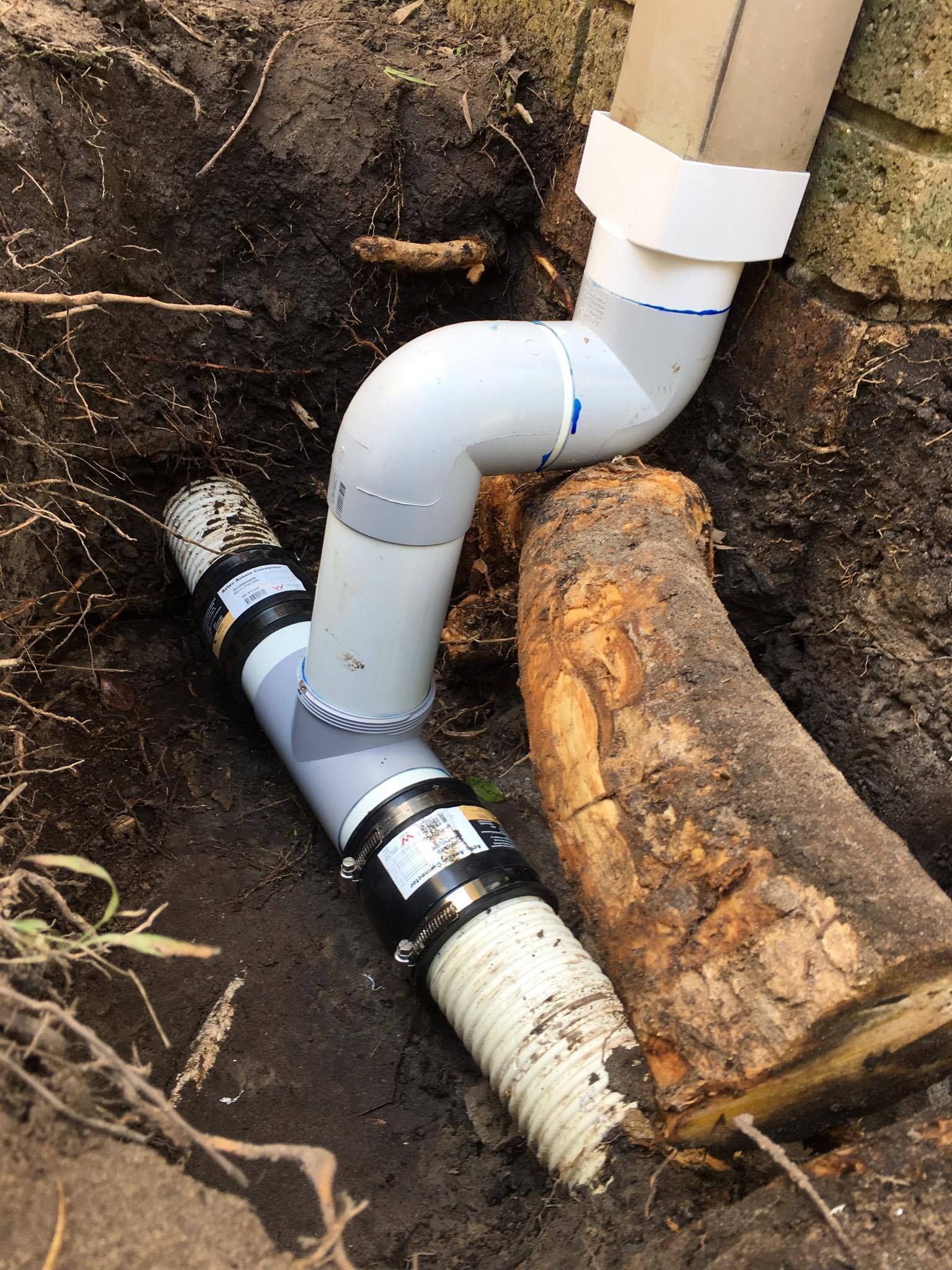Drainage System With Gray Pvc Pipes and Black Couplings in a Dirt Trench — Hills 2 Ocean Plumbing in Maclean, NSW