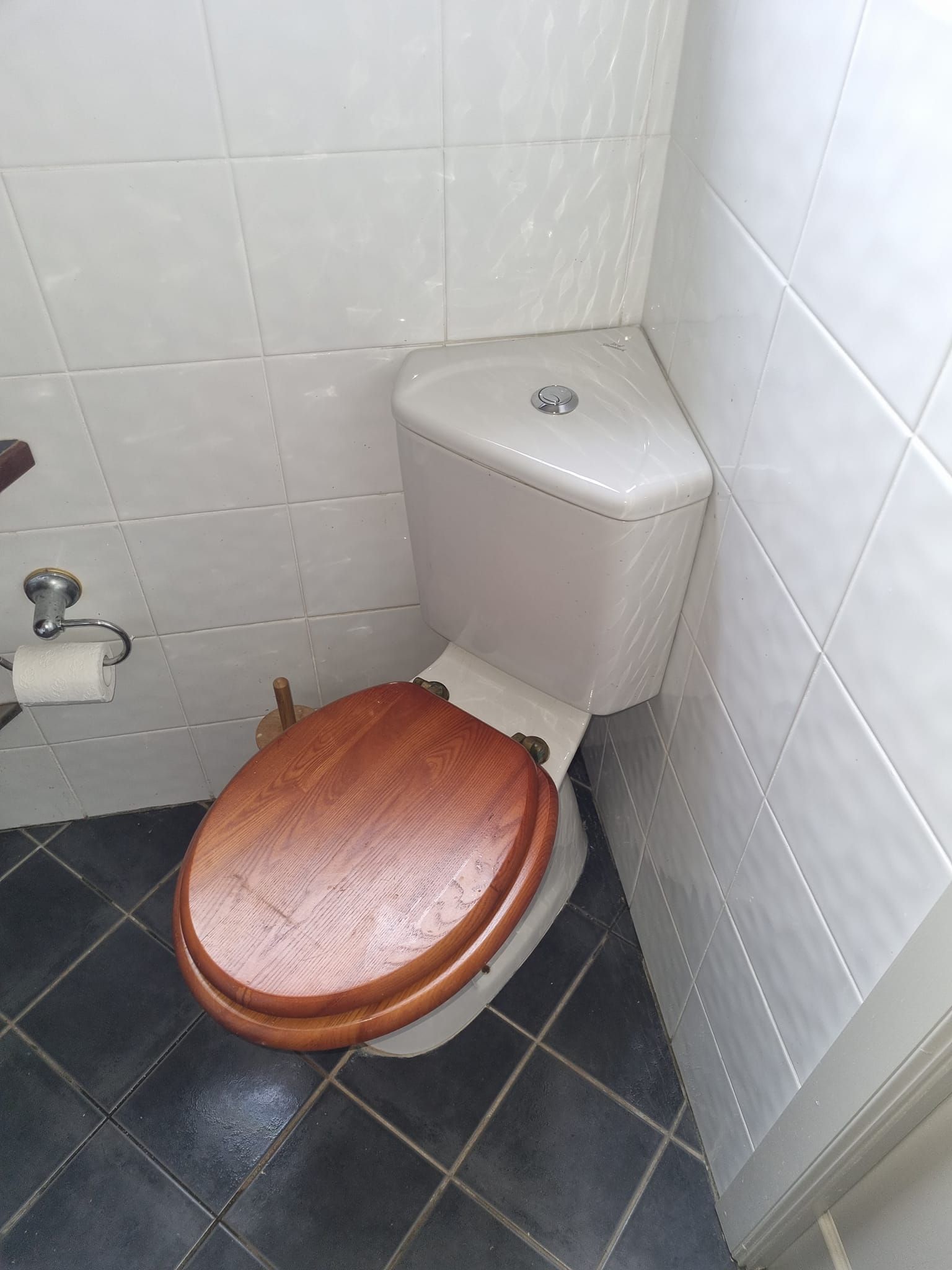 Toilet in a Small Bathroom Corner With White Tiles — Hills 2 Ocean Plumbing in Maclean, NSW