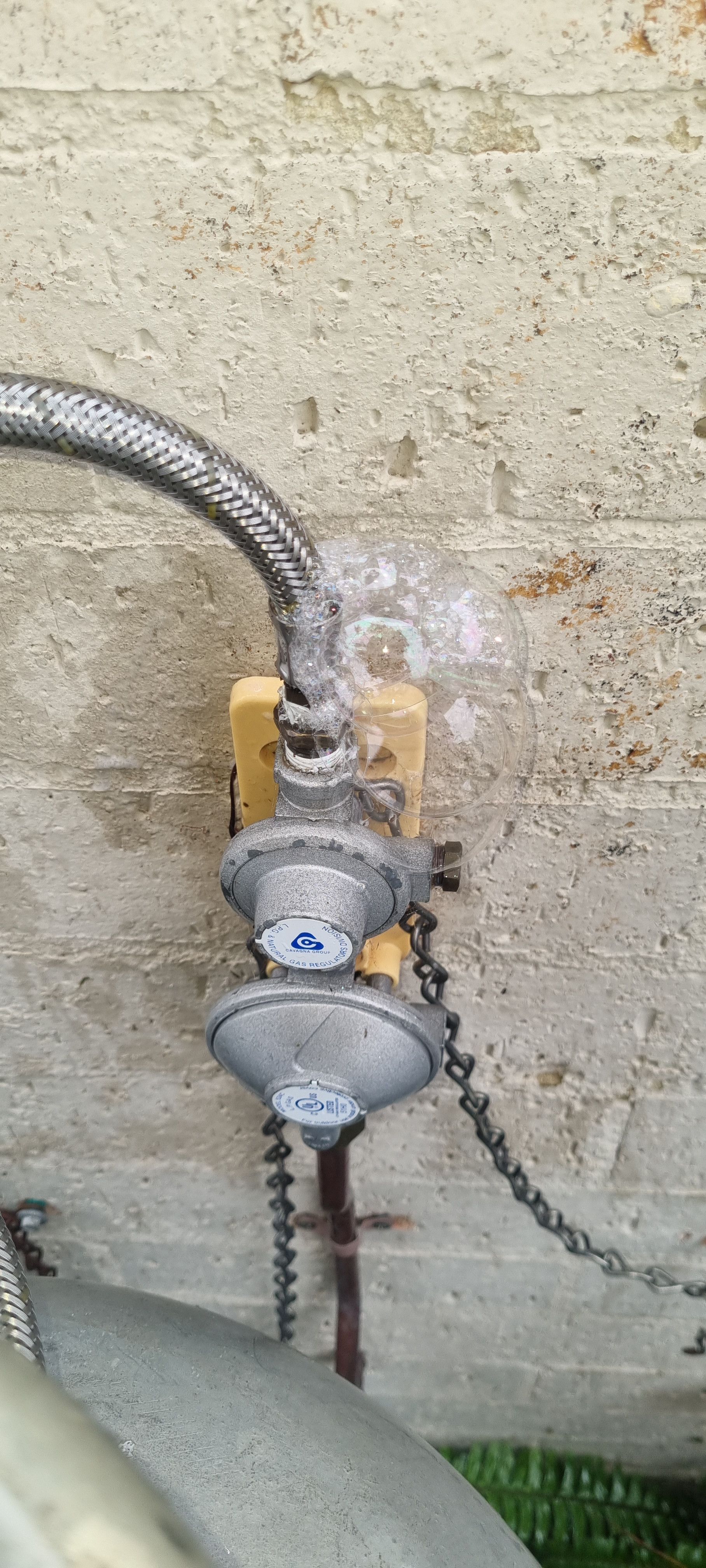 Gas Regulator with Flexible Hose Attached to A Concrete Surface— Hills 2 Ocean Plumbing in Maclean, NSW