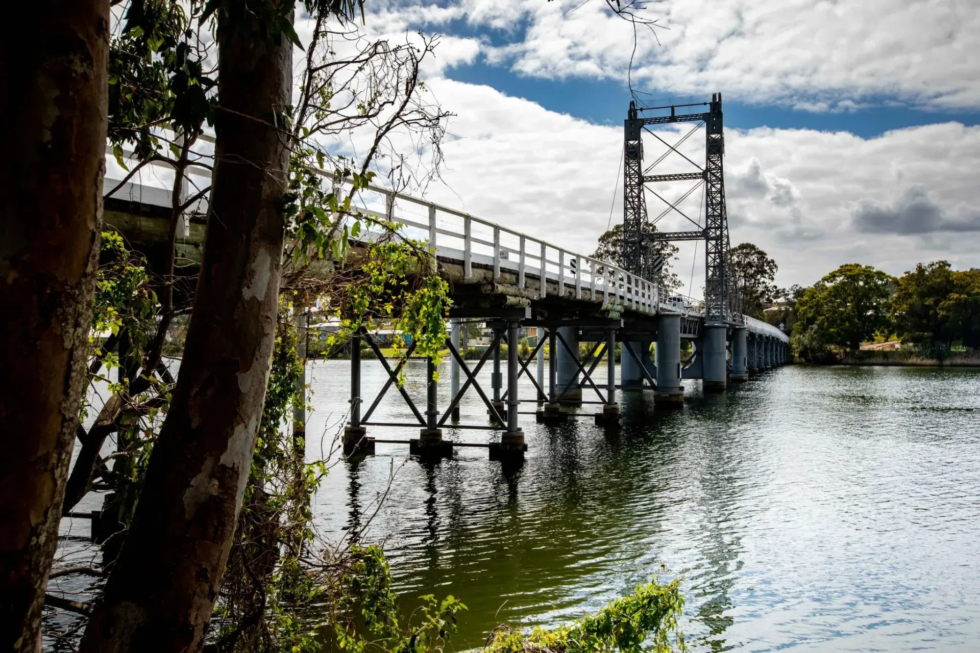 Wooden Bridge Over Water with Vertical Metal Tower and Trees — Hills 2 Ocean Plumbing in Maclean, NSW