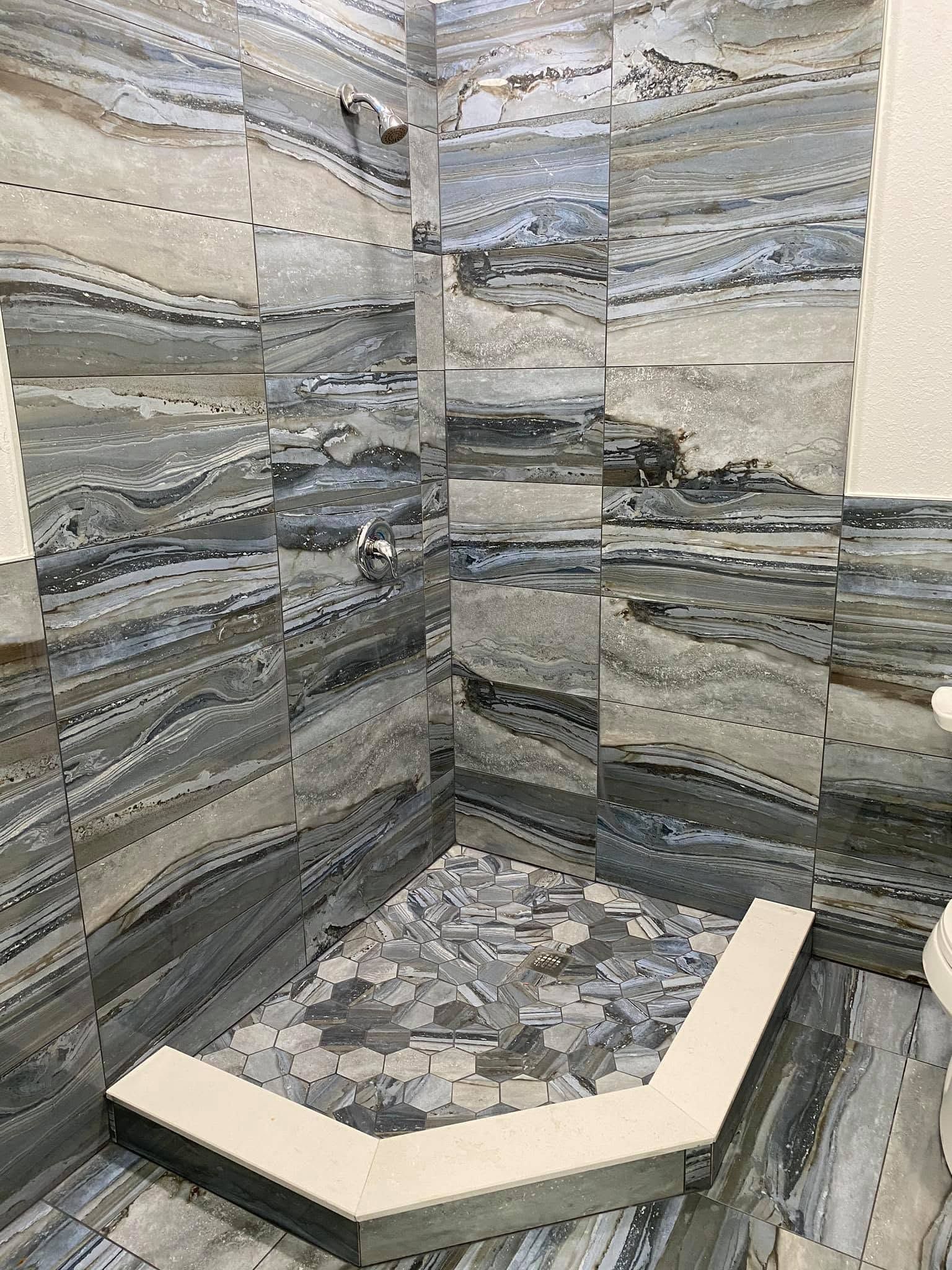 Modern stone-tile shower corner with a built-in bench and beige seat ledge