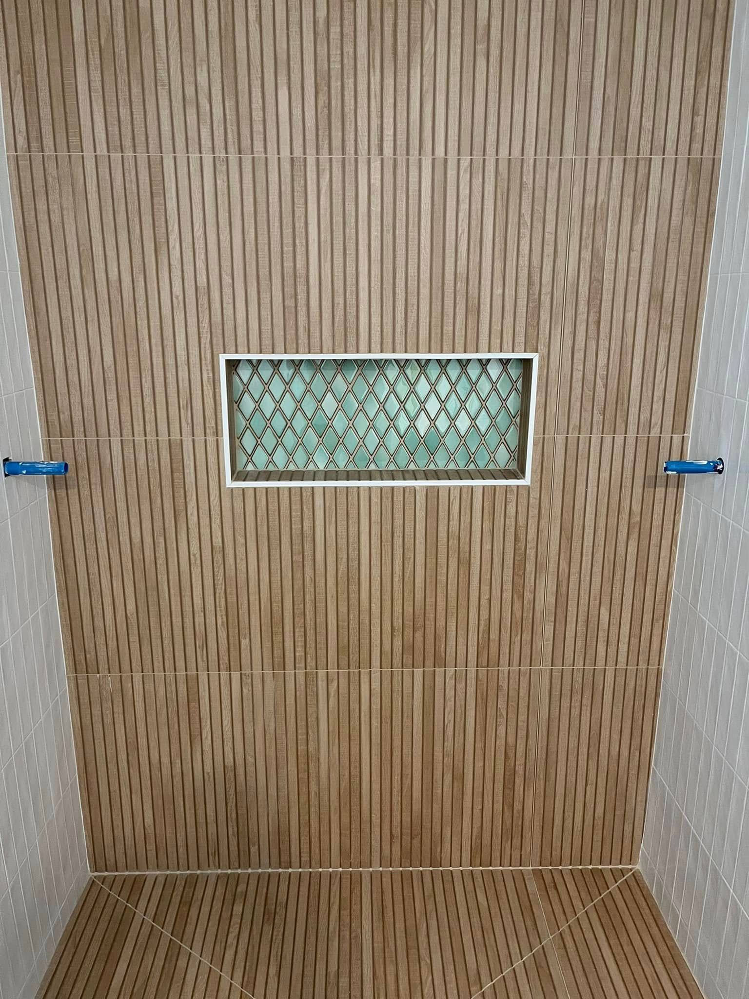 Wood-paneled shower stall with a small frosted glass window in the center.