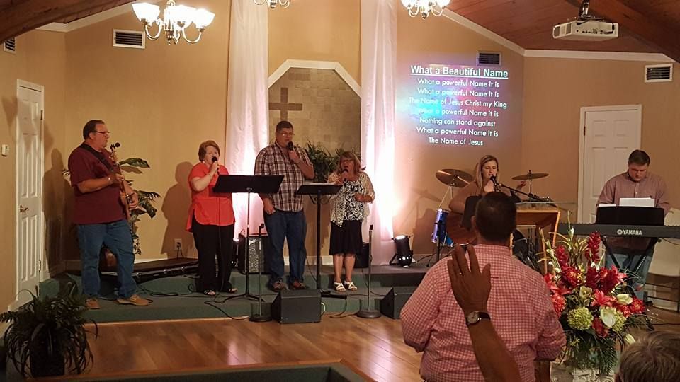A group of people are singing and playing instruments in a church.