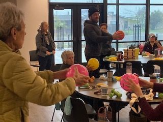 a group of people are sitting at tables playing with balloons