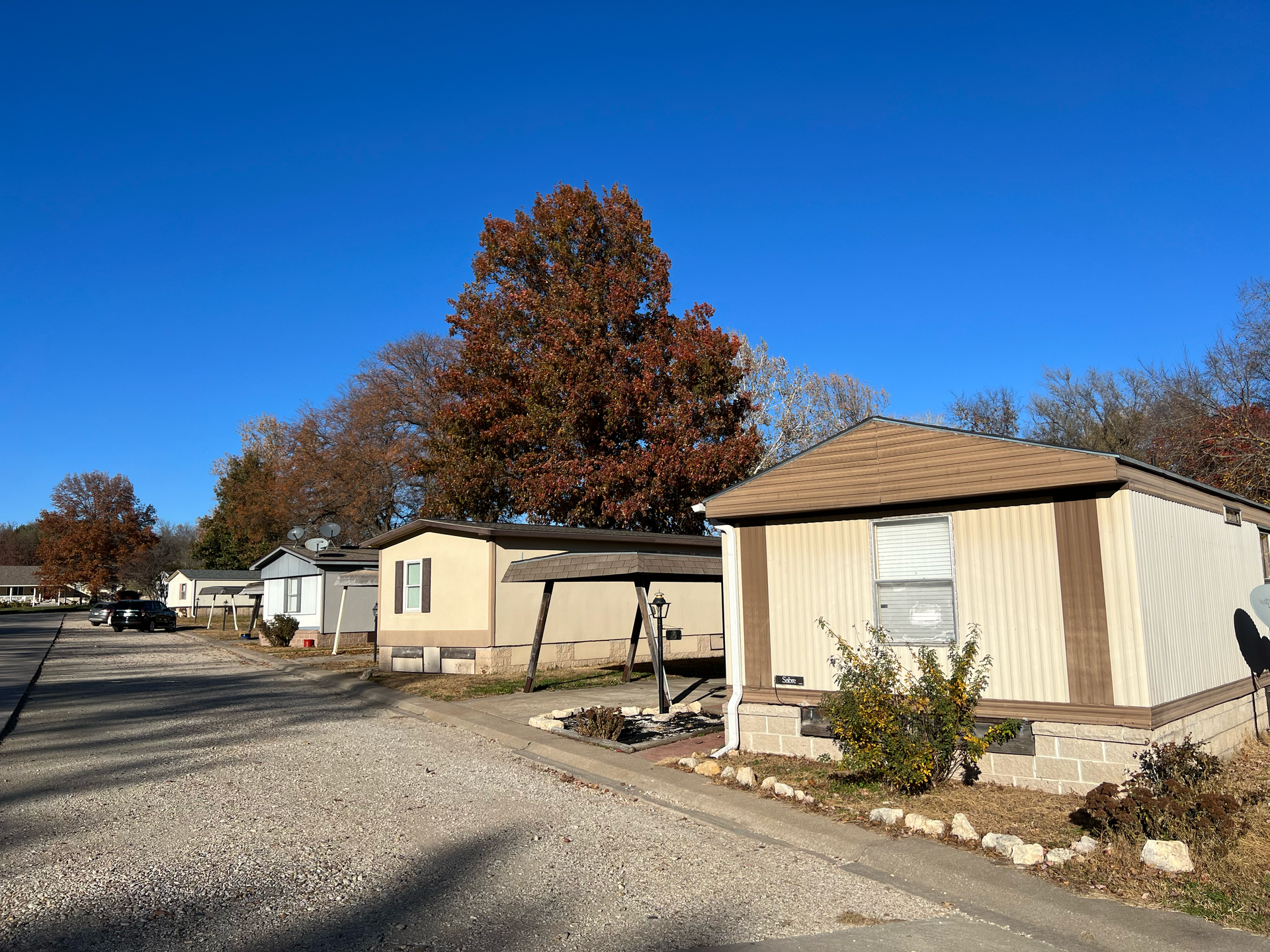 A row of mobile homes in a mobile home park on a sunny day.
