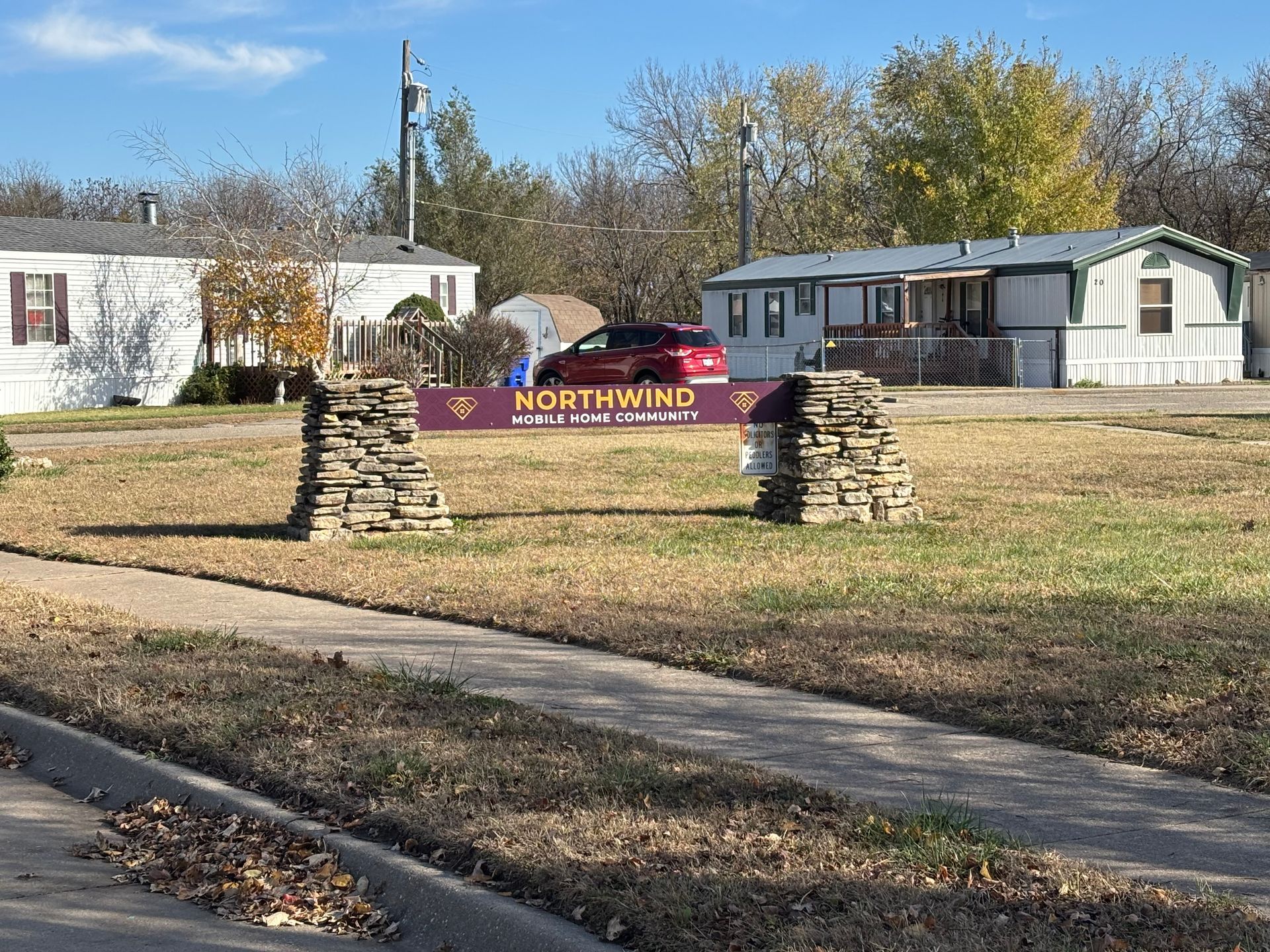 A mobile home park with a sign in the middle of the field.