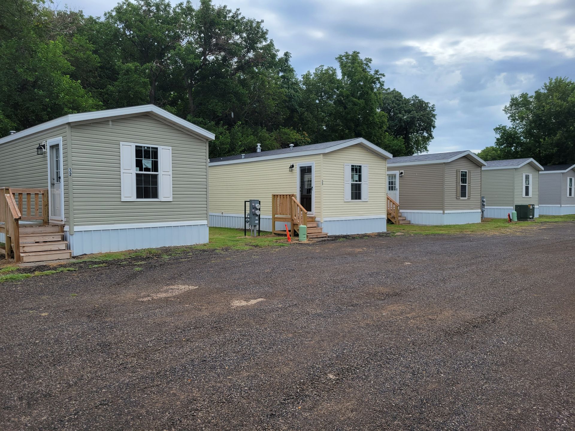 A row of mobile homes are lined up in a parking lot.