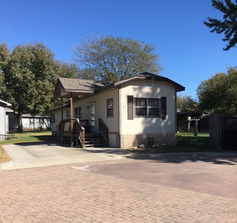 A mobile home with a brick driveway and stairs