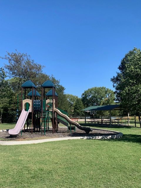 A playground in a park with a blue sky in the background