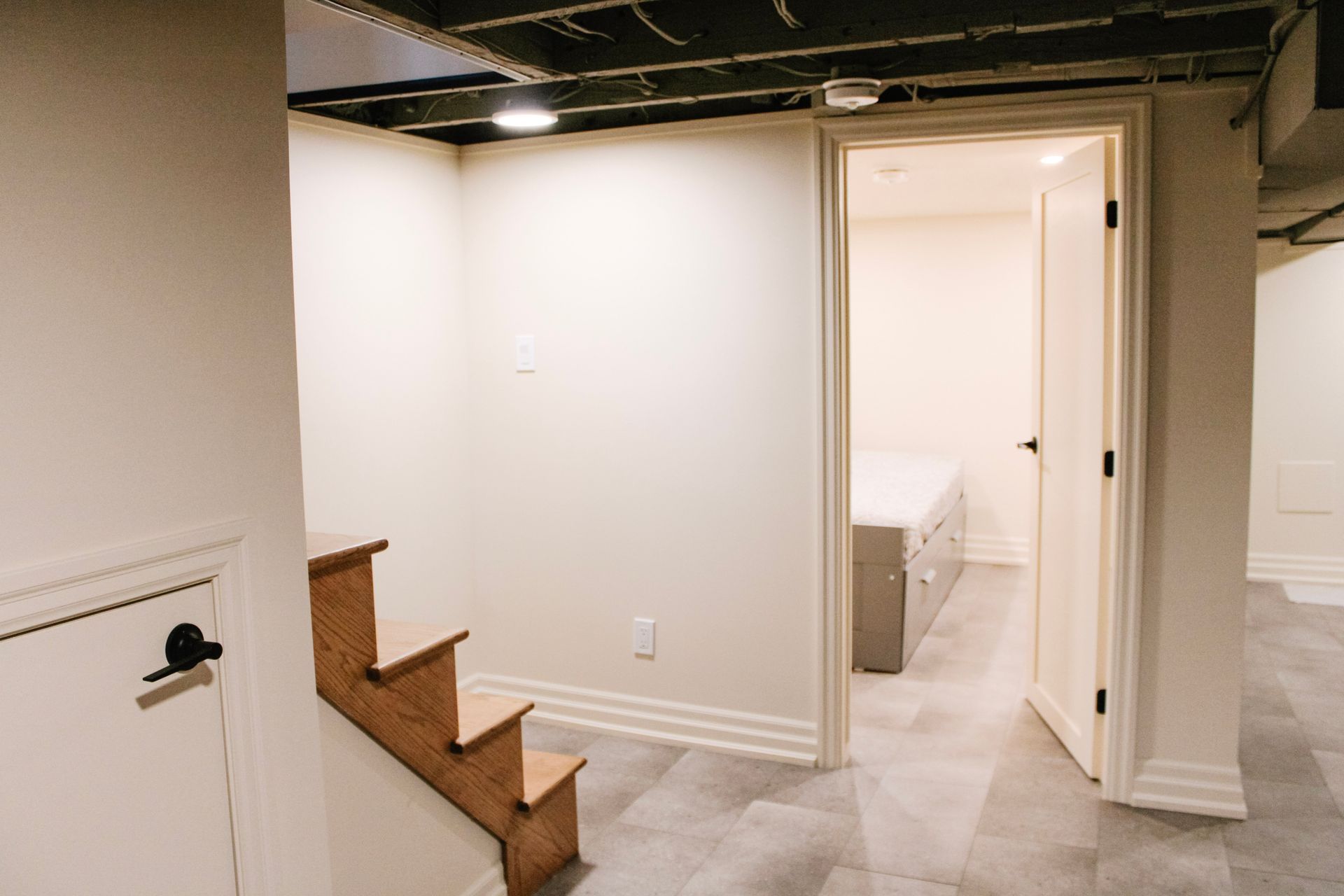 Powder room with charcoal cabinetry, floor to ceiling linen tower, brass fixtures and arched wood mirror, Hamilton Ontario