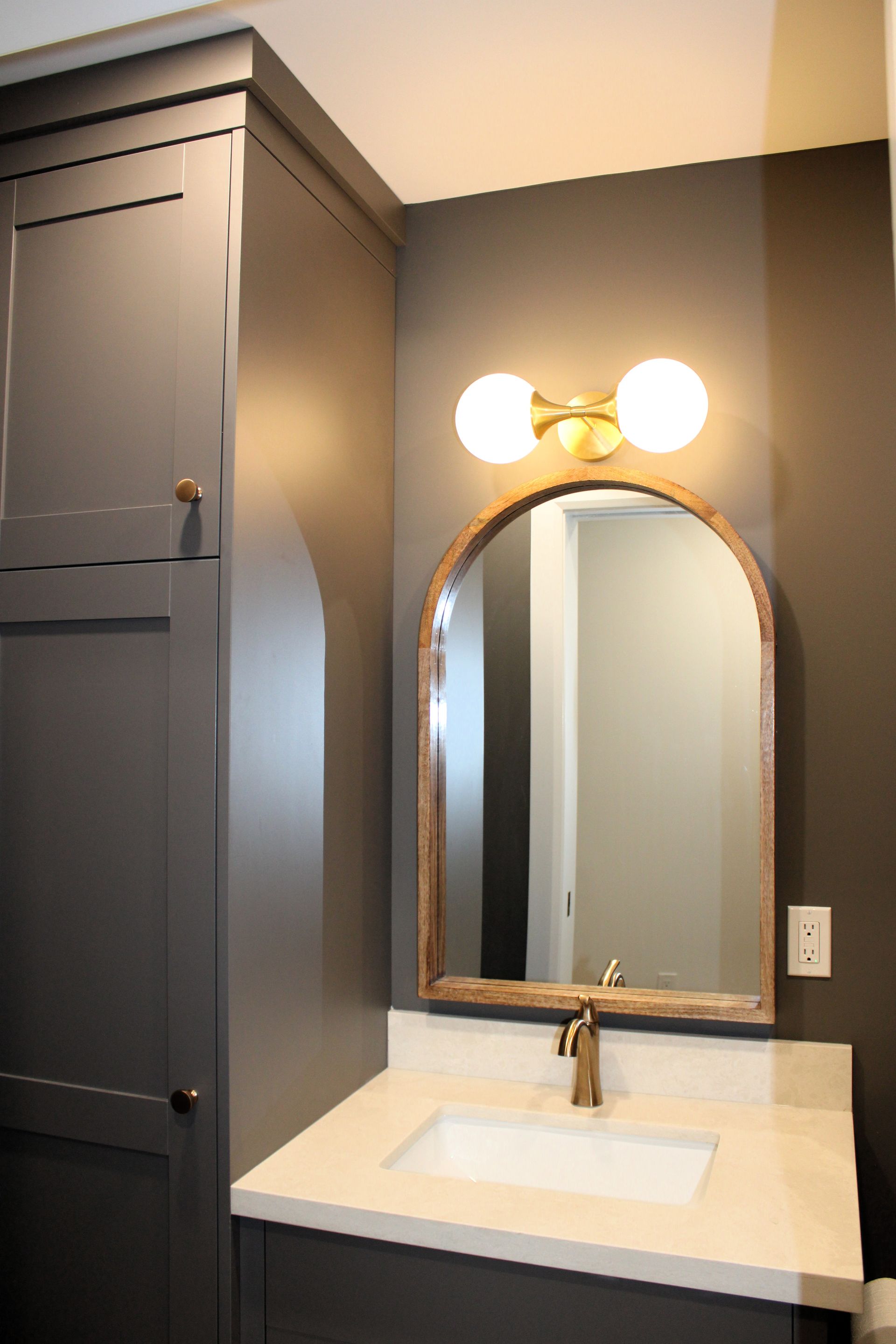 Wide view of a completed ensuite renovation with wood look tile flooring, glass shower with recessed niches and custom vanity, Hamilton Ontario
