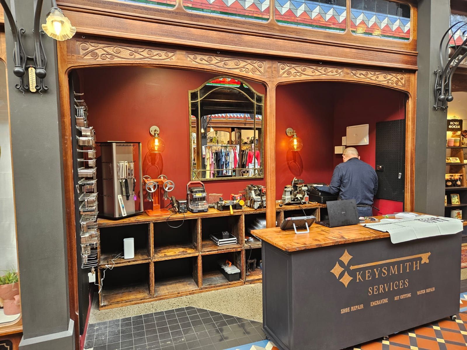 Coffee shop counter with espresso machine, grinders, and hanging globe lights.