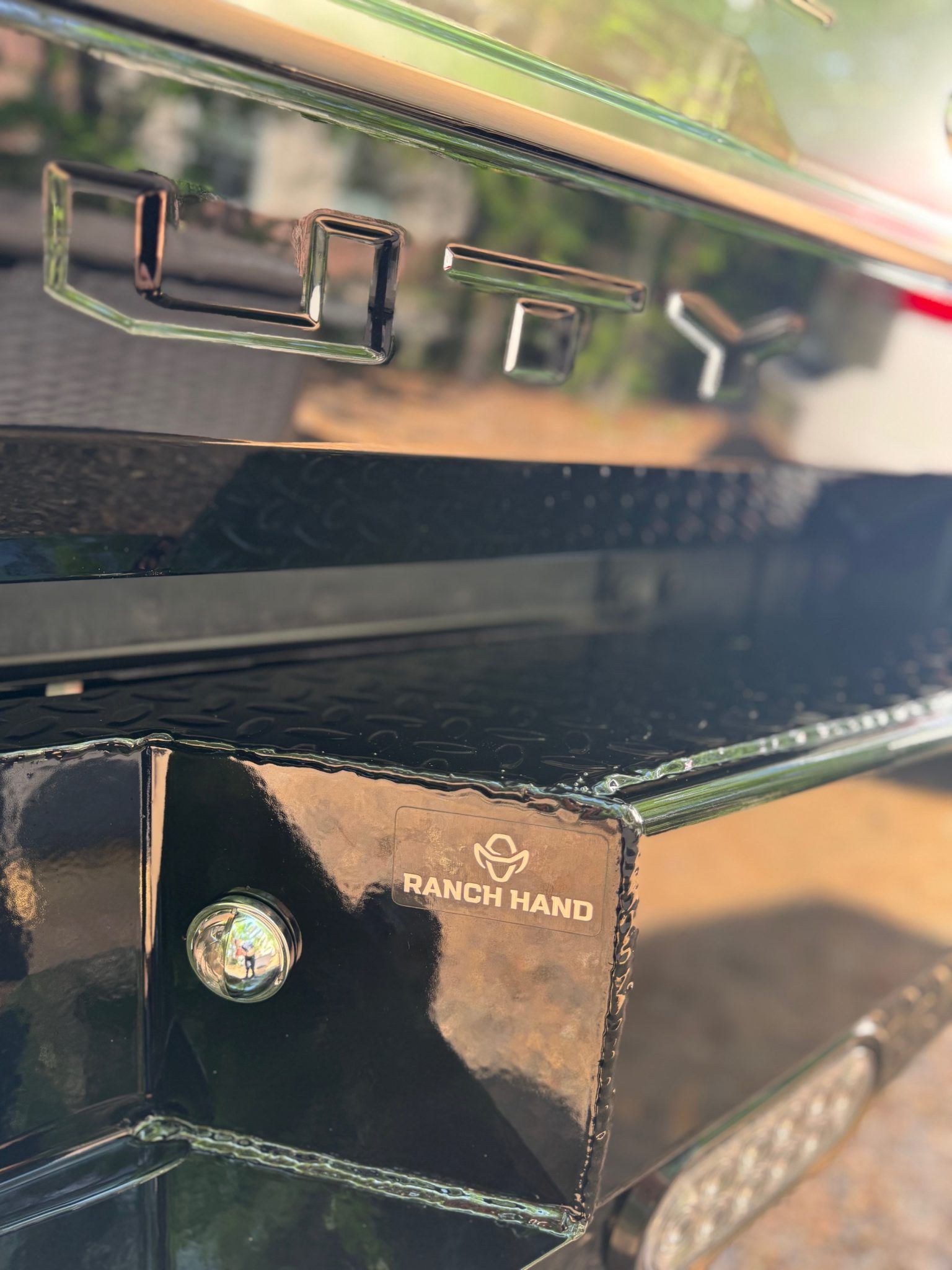 Close-up of a glossy black Range Hani appliance panel with illuminated buttons and reflections