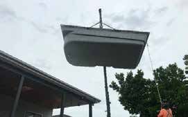 A large bathtub is being lifted into the air by a crane.