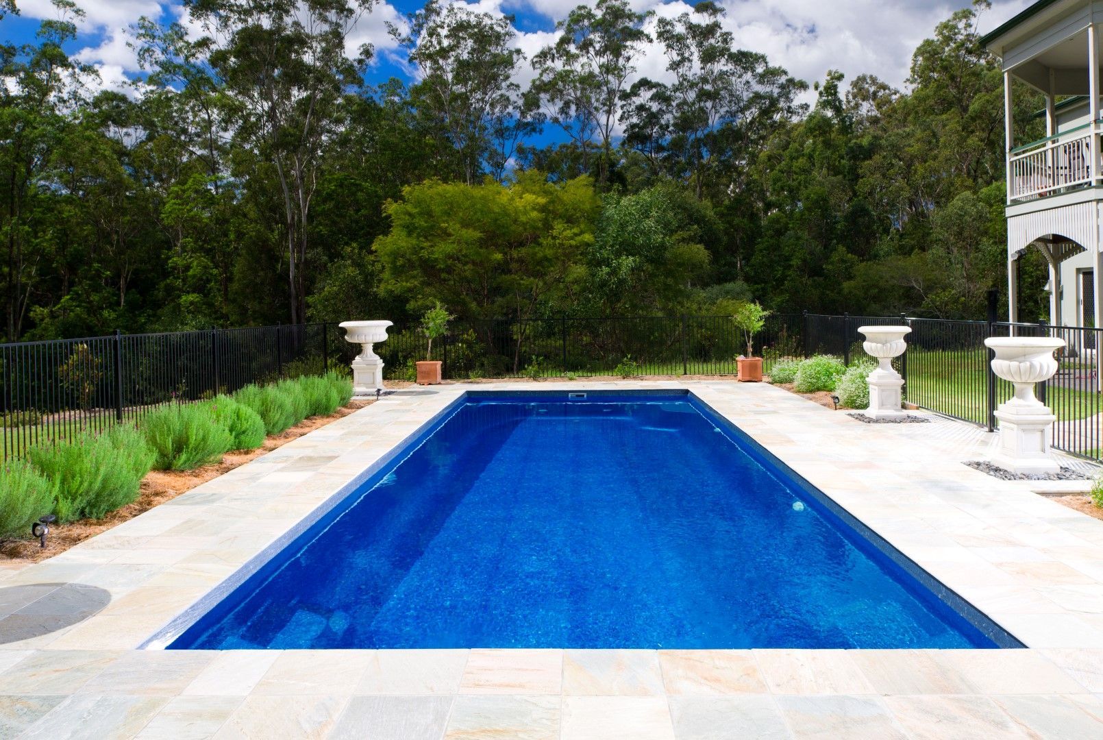 A large blue swimming pool in front of a house