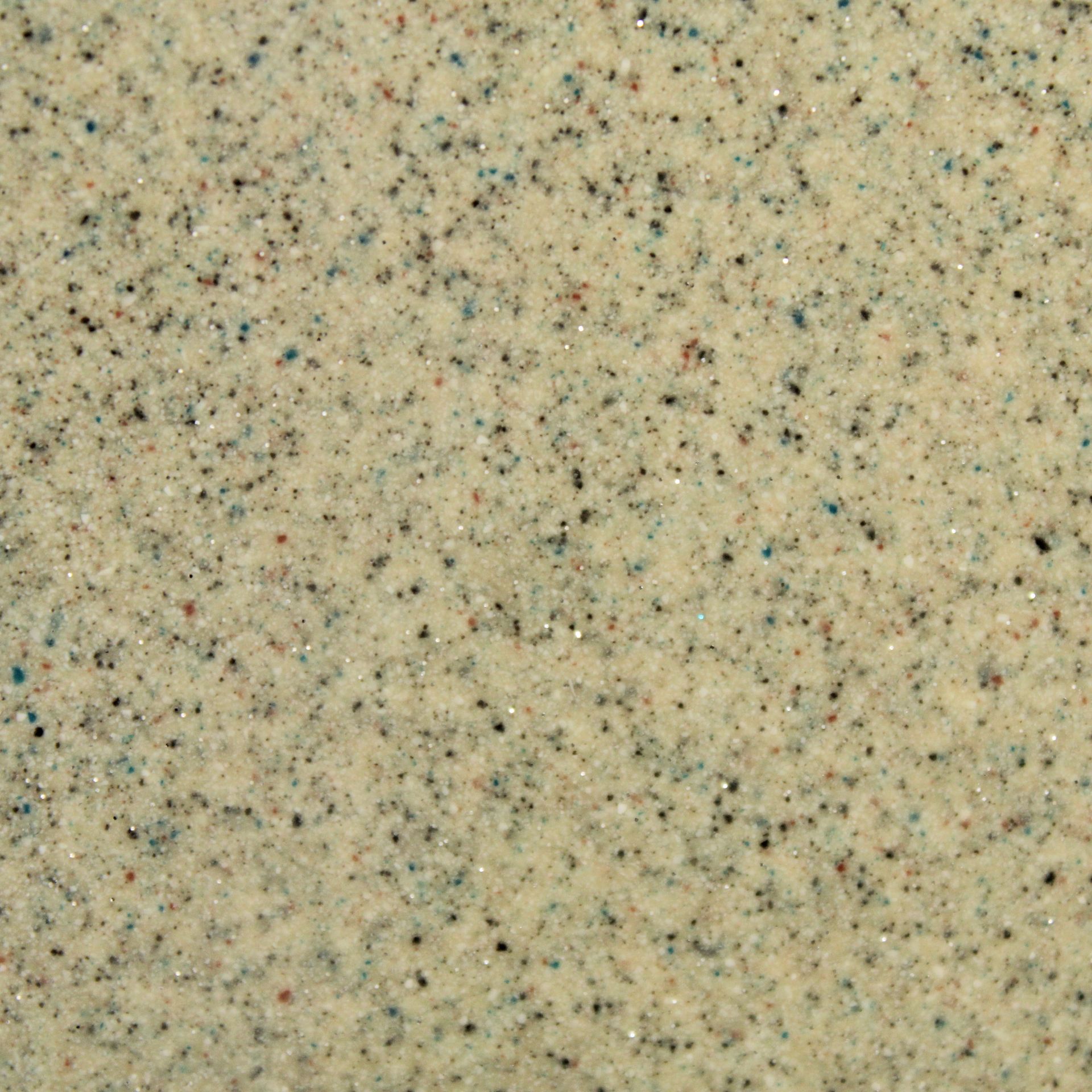 Beige speckled textured surface with small black and brown flecks