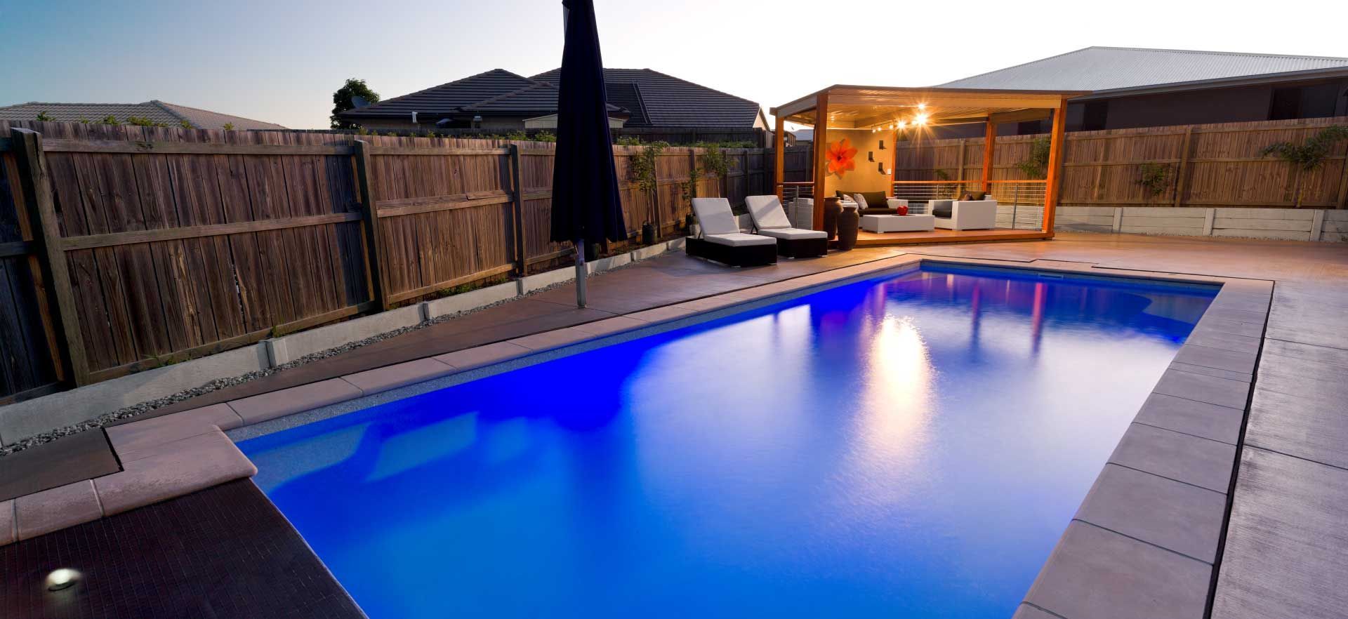 A large swimming pool is lit up with blue lights
