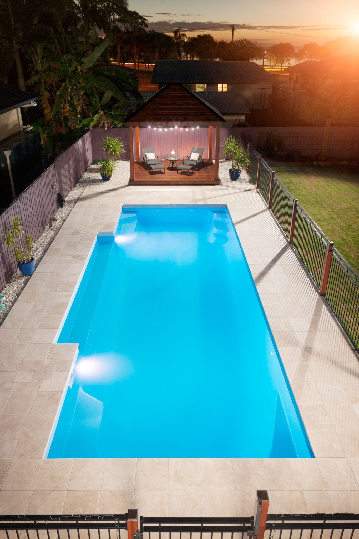 An aerial view of a large swimming pool in a backyard.
