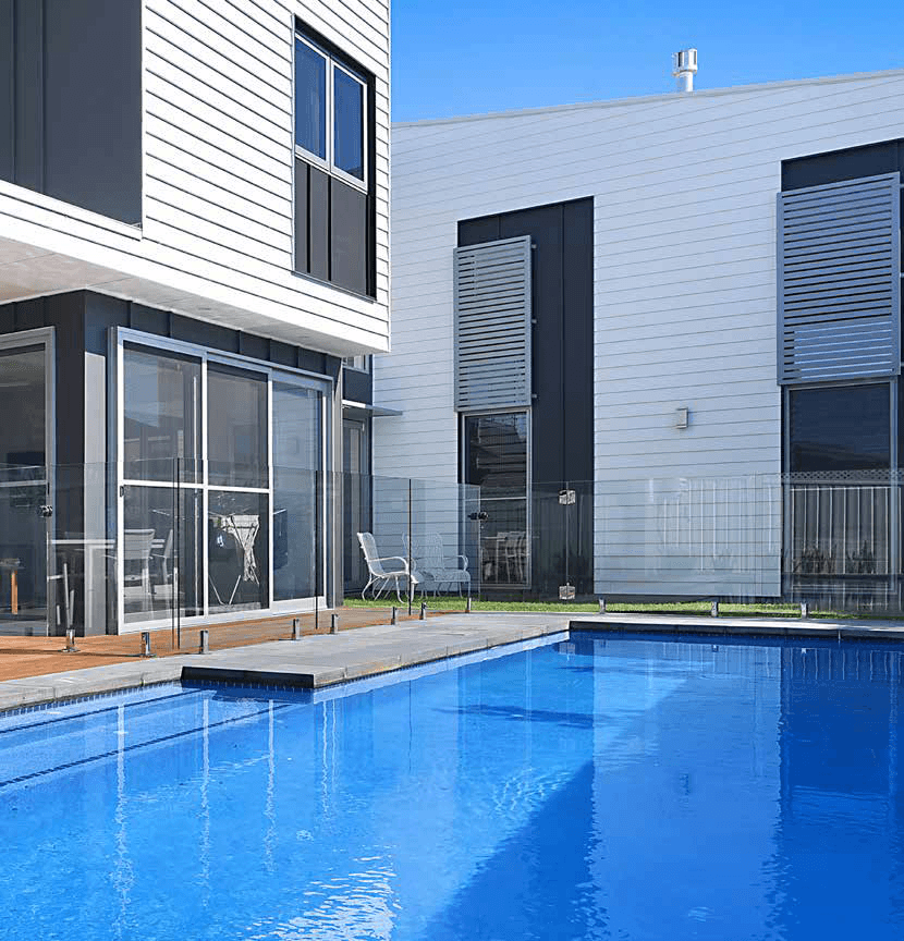 A large swimming pool in front of a house