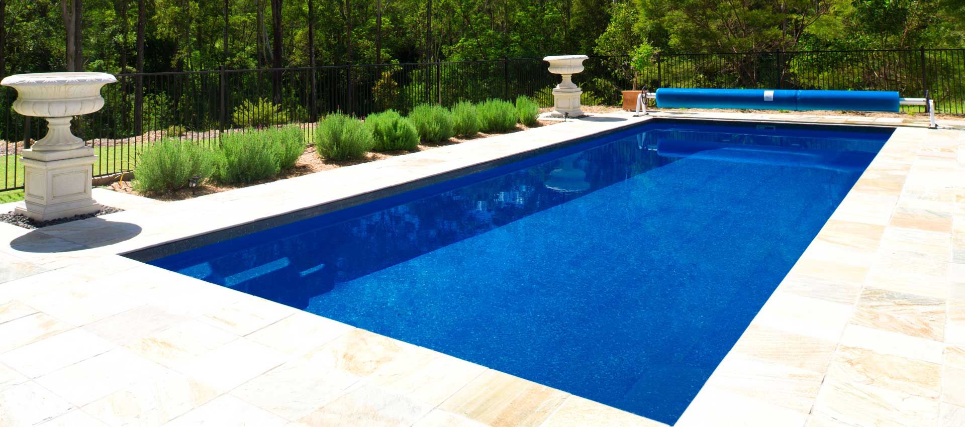 A large blue swimming pool with a fence around it