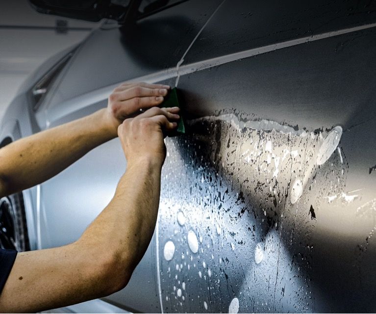Installing Paint Protection Film on a black vehicle in Miami, FL.