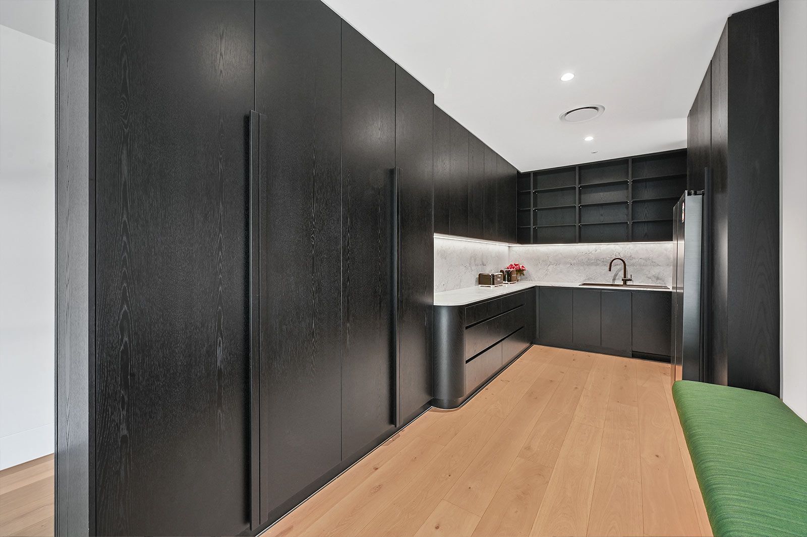 Black-panelled kitchen with wooden floors, white countertops, and open shelving — PK Kitchen Design in West Ipswich, QLD