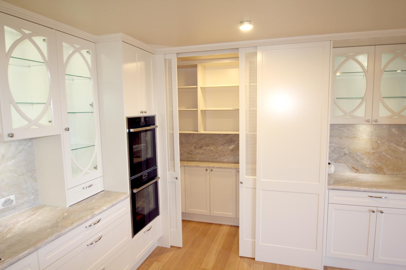 White Kitchen With Built-in Oven, Pantry, and Cabinets — PK Kitchen Design in West Ipswich, QLD
