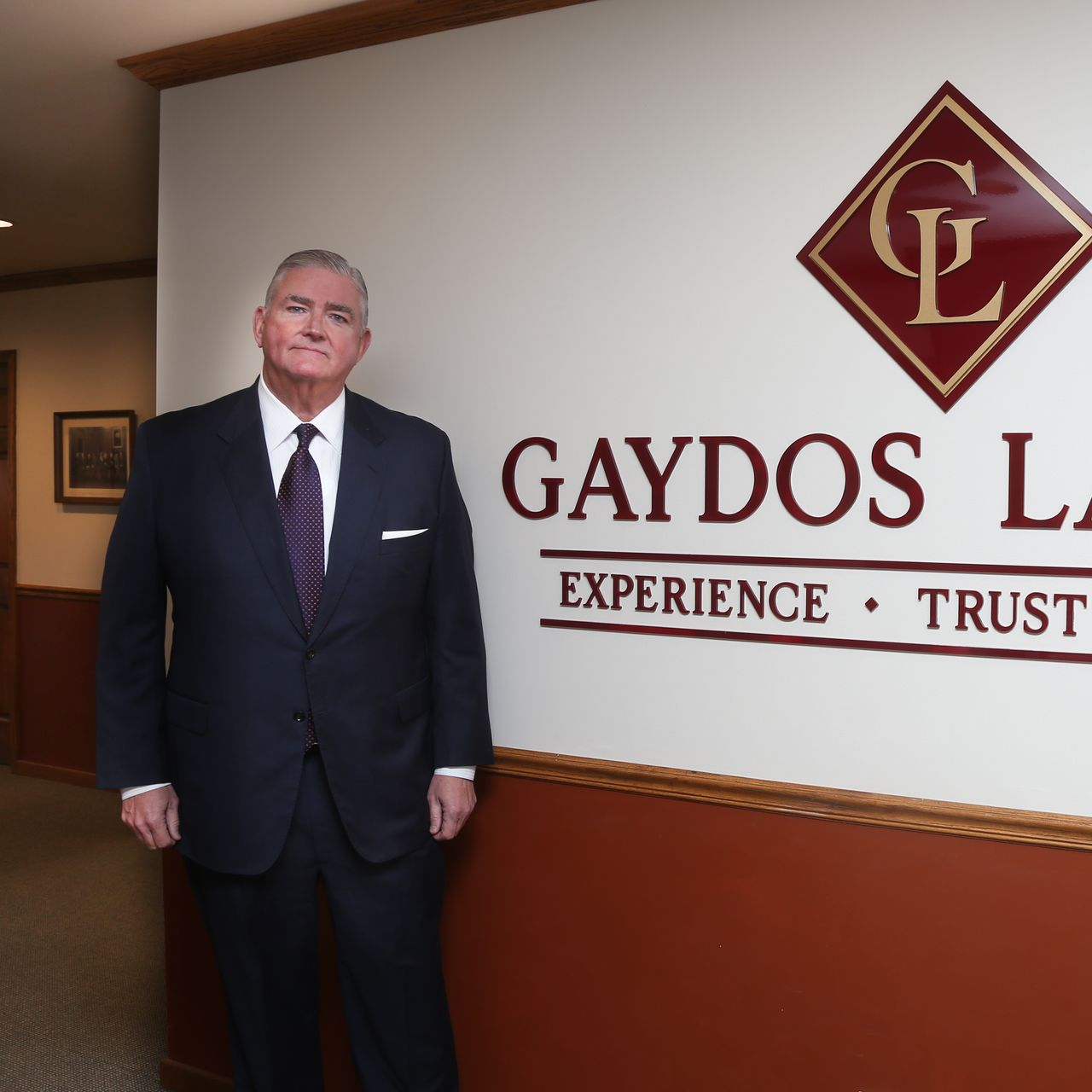 Joe Gaydos standing by sign that says Gaydos Law, P.C.