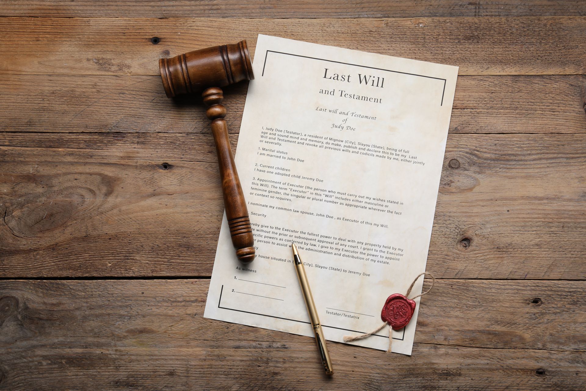 Last Will and Testament document, gavel, and pen on wooden table.