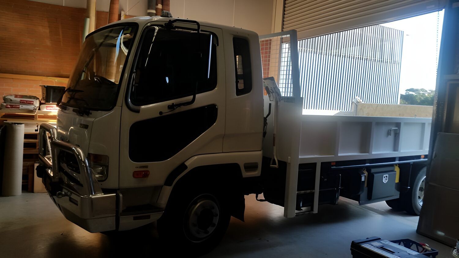 A White Dump Truck Is Parked In A Garage — Solartint South Coast (Juz Tint) In Batemans Bay, NSW