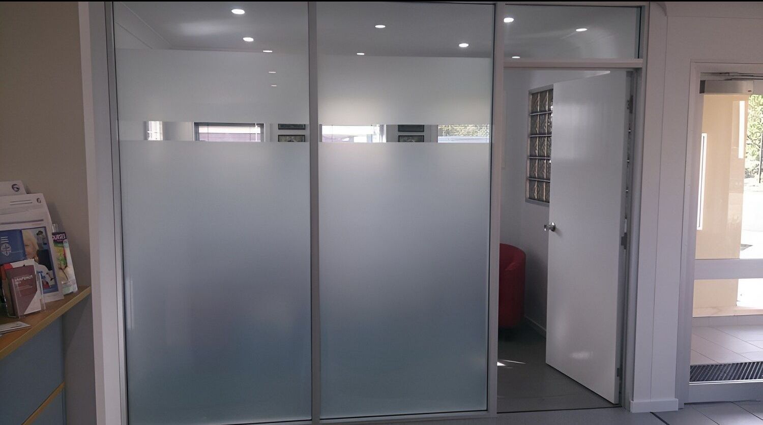 A Room With A Door And A Shelf With Magazines On It — Juz Tint In Moruya, NSW