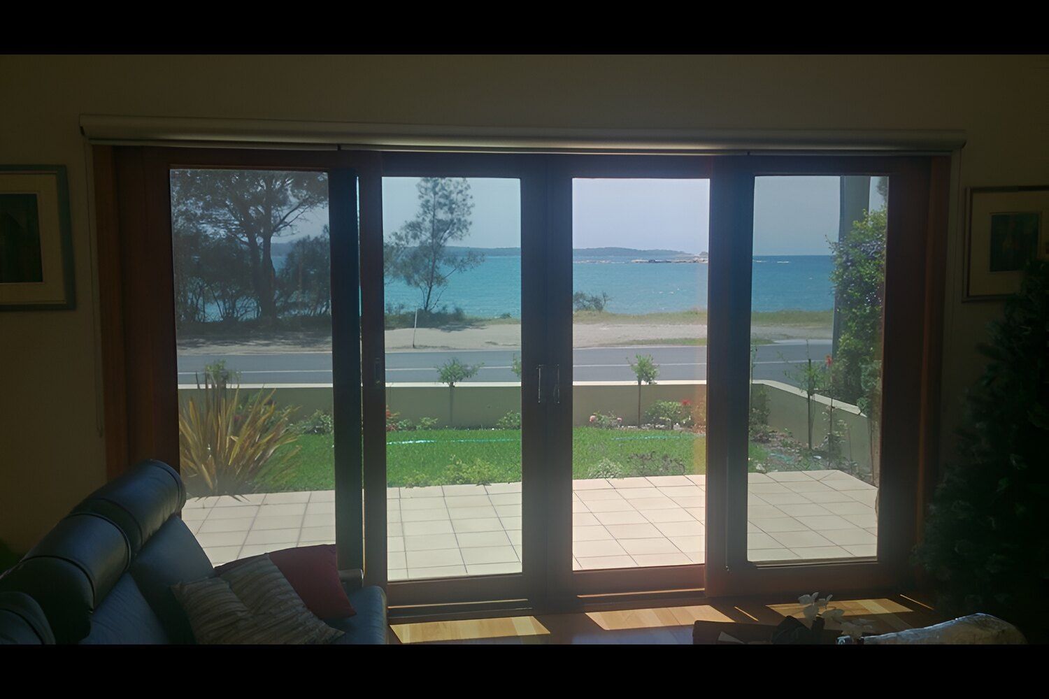 A Living Room With A View Of The Ocean Through The Sliding Glass Doors — Juz Tint In Braidwood, NSW