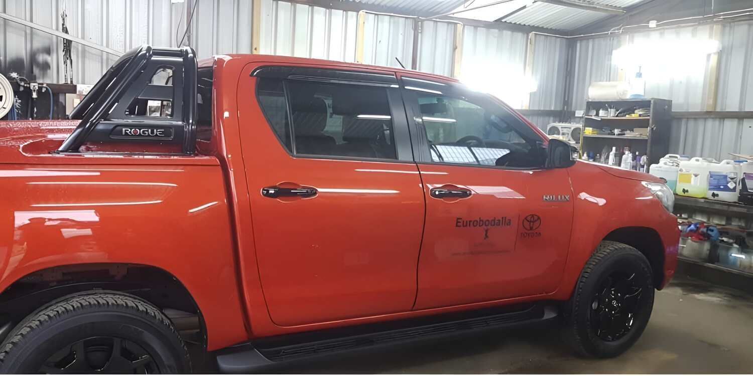A Red Truck And A White Truck Are Parked In A Garage — Juz Tint In Batemans Bay, NSW