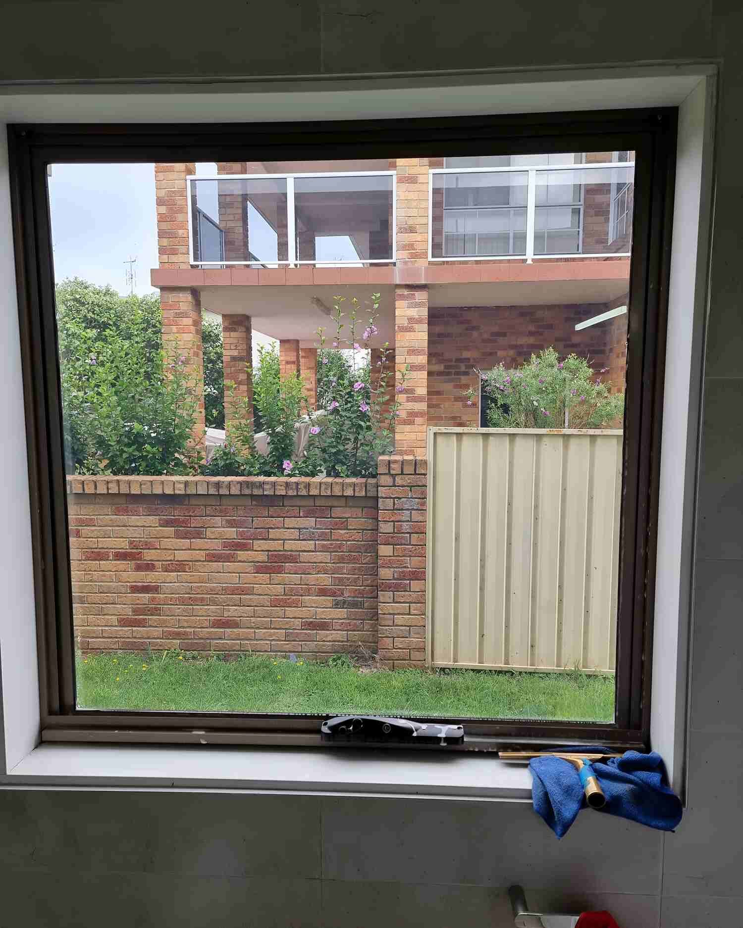 A Window With A View Of A Brick Building And A Fence — Solartint South Coast (Juz Tint) In Batemans Bay, NSW