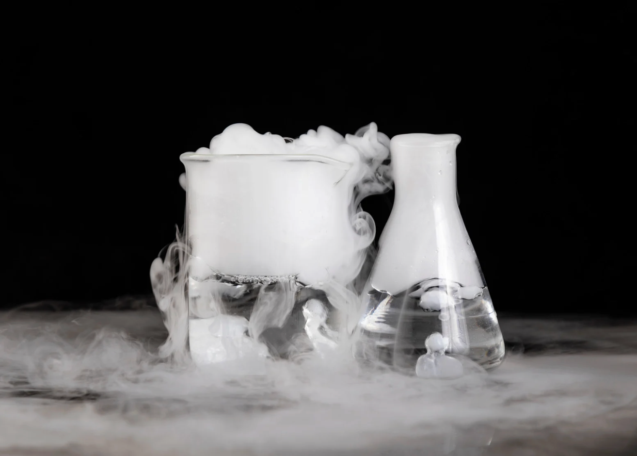 Two glass beakers emitting white vapor on a black background