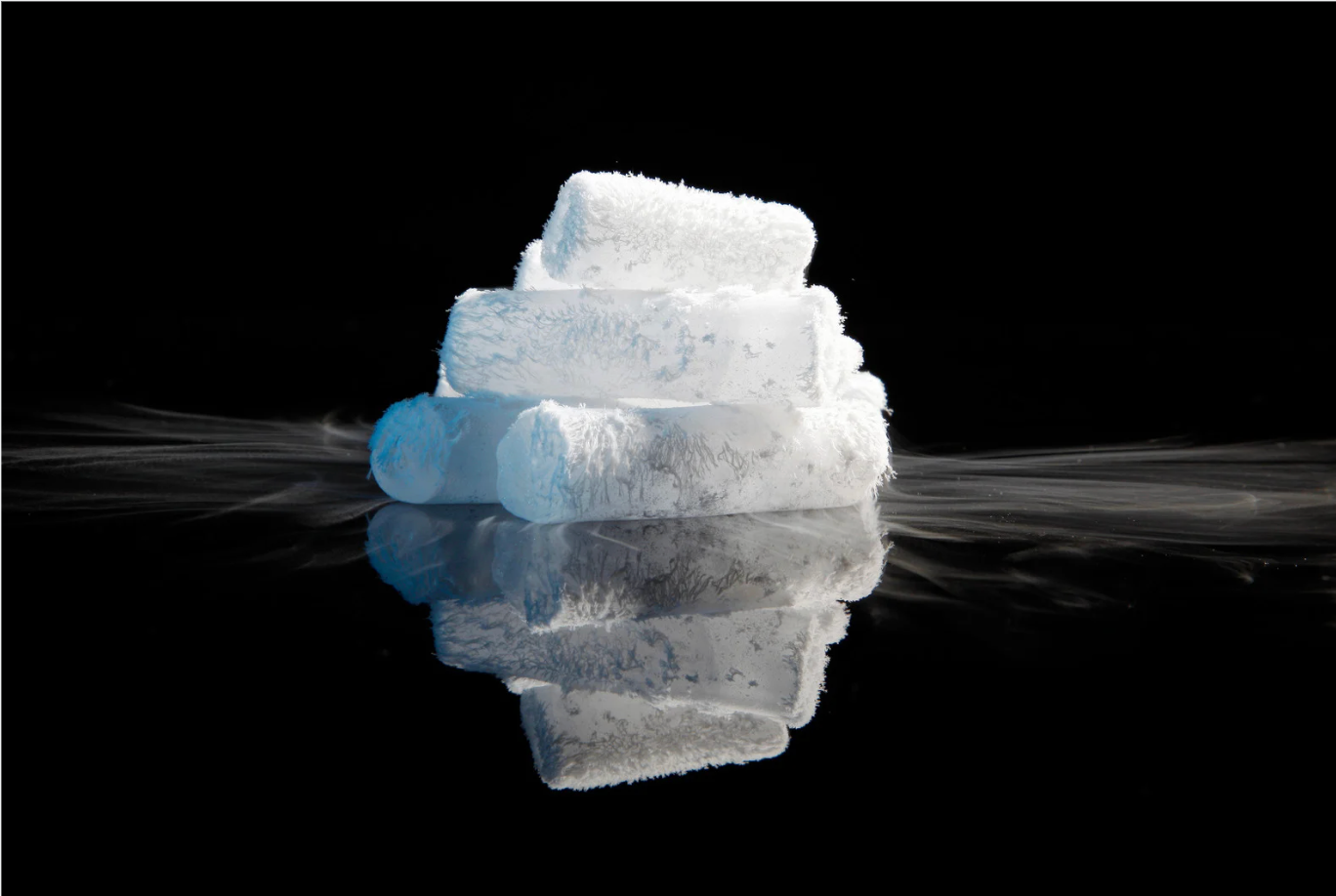 Stacked ice cubes on a dark background, with one blue-tinted cube on the left