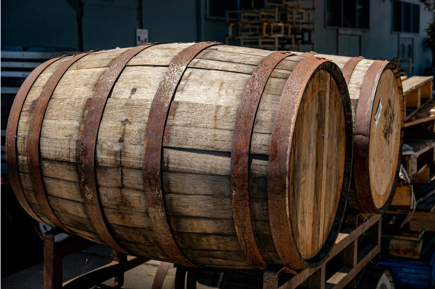 Wooden barrels stacked in a dim industrial workshop